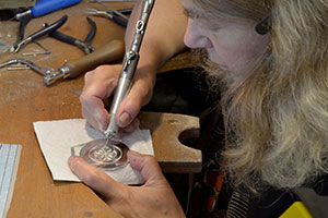 Rhiannon engraving a pendant